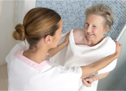 senior woman taking a bath assisted by caregiver